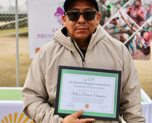 Valley Pruning Contest – California Farmworker Foundation Farmworker smiling during the Central Valley Pruning Contest held by California Farmworker Foundation