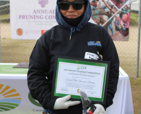 Valley Pruning Contest – California Farmworker Foundation Farmworker smiling during the Central Valley Pruning Contest held by California Farmworker Foundation